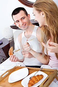 Happy smiling man and positive girlfriend with tasty breakfast