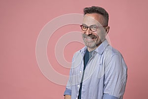 Happy smiling mature man wearing spectacles and looking at camera indoor. Man with beard and glasses feeling confident. Handsome