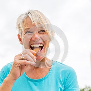 Mature woman bites in a carrot