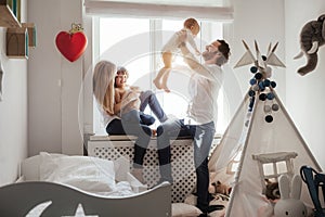 Family playing and spending time near window. Sunny day outside