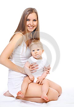 Happy smiling mother and baby sitting on white