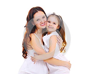 Happy smiling mother hugging little child daughter on white