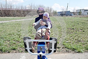 Happy smiling mother and little girl outdoor workout together on trainer outside in early spring nature park. Sport, maternity