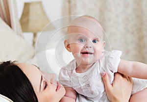 Happy smiling mother with six month old baby girl