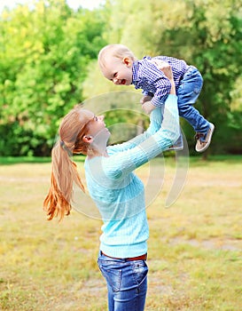 Happy smiling mother with son child having fun outdoors