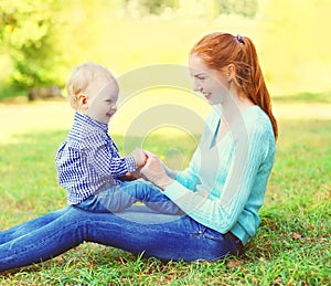 Happy smiling mother and son child having fun outdoors