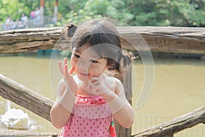 Happy smiling portrait of a 2 year old girl in the park