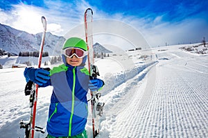 Happy smiling portrait of a boy with ski on slope