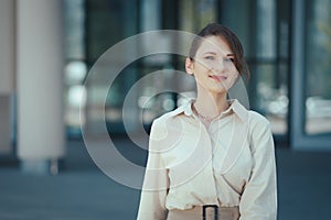 Happy smiling portrait of caucasian female company leader CEO boss executive standing in front of office building