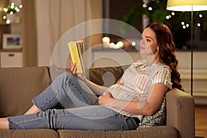 Happy smiling pregnant woman reading book at home