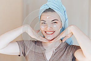 Happy smiling pretty beautiful woman girl with towel on head smiling touch healthy clean soft moisturized hydrated skin care after
