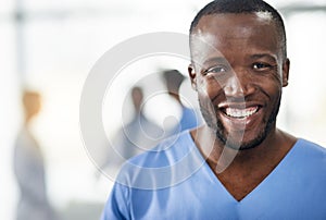 Happy, smiling and professional doctor in a hospital closeup portrait with blurred background. Confident black male
