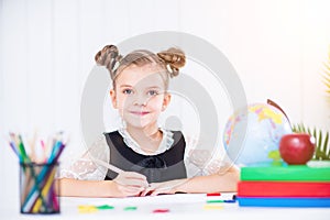 Happy smiling pupil at the desk. Girl in the class room with pencils, books. Kid girl from primary school. first day of