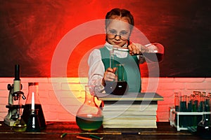 Happy smiling pupil drawing at the desk. School chemistry lessons. They carried out a new experiment in chemistry