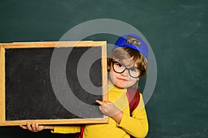 Happy smiling pupils drawing at the desk. Cheerful smiling child at the blackboard. Classroom. September 1. Back to