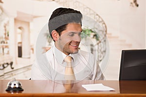 Happy smiling receptionist in hotel looking friendly for the guests in hotel background