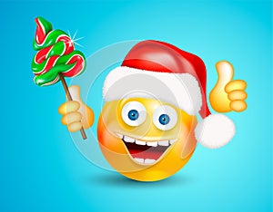 Happy smiling round face wearing a red santa claus hat holding christmas candies fir-tree and showing thumb up on bright blue back