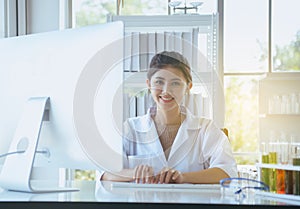 Happy and smiling scientist asian women working and using computer keyboard on desk in office room,Fingers typing close up