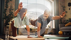 Happy Smiling Senior Couple Doing Gymnastics and Yoga Stretching Exercises Together at Home on Sunny