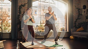 Happy Smiling Senior Couple Doing Gymnastics and Yoga Stretching Exercises Together at Home on Sunny