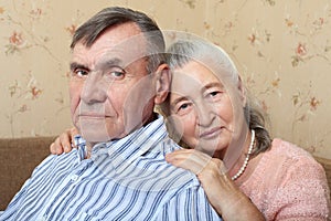 Happy smiling senior couple embracing together at home