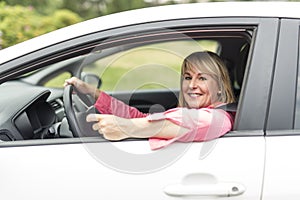 Happy and smiling senior woman in black car