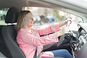 Happy and smiling senior woman in black car