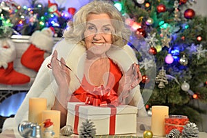 Happy smiling senior woman with gift on Christmas