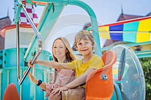 happy smiling son and his mother spending fun time together at amusement park