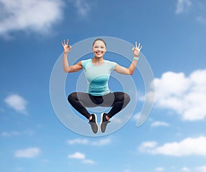 Happy smiling sporty young woman jumping in air