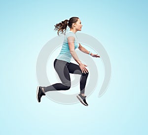Happy smiling sporty young woman jumping in air