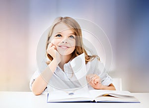 Happy smiling student girl reading book