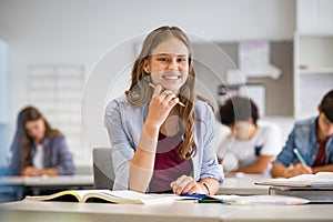 Happy smiling student girl studying in classroom