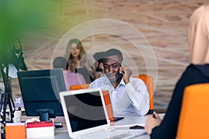 Happy smiling successful African American businessman in in a modern bright startup office indoors