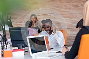 Happy smiling successful African American businessman in in a modern bright startup office indoors