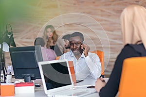 Happy smiling successful African American businessman in in a modern bright startup office indoors