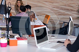 Happy smiling successful African American businessman in in a modern bright startup office indoors