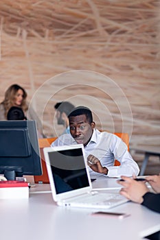 Happy smiling successful African American businessman in in a modern bright startup office indoors