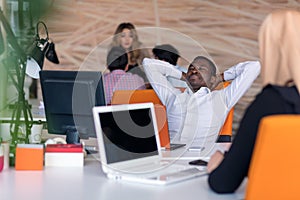 Happy smiling successful African American businessman in in a modern bright startup office indoors