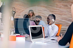 Happy smiling successful African American businessman in in a modern bright startup office indoors