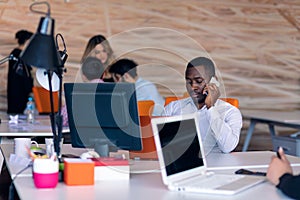 Happy smiling successful African American businessman in in a modern bright startup office indoors