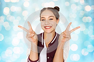 Happy smiling teenage girl showing peace sign
