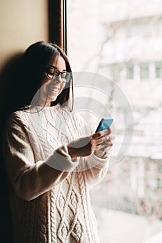 Happy smiling teenage girl texting on cell phone