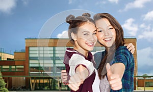 happy smiling teenage girls showing thumbs up