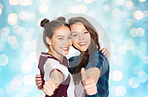 Happy smiling teenage girls showing thumbs up