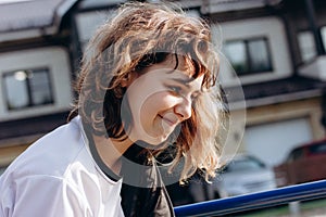 Happy smiling teenager girl with curly hair outdoors