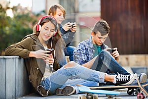 Happy smiling teens playing on smarthphones