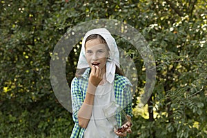 Happy smiling with teeth white caucasian young woman, teen girl holds glass jar, eats some berries (raspberries)