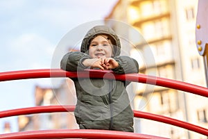 Happy smiling three year old toddler boy on the playground looking into the distance.