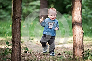 Happy smiling toddler in forest